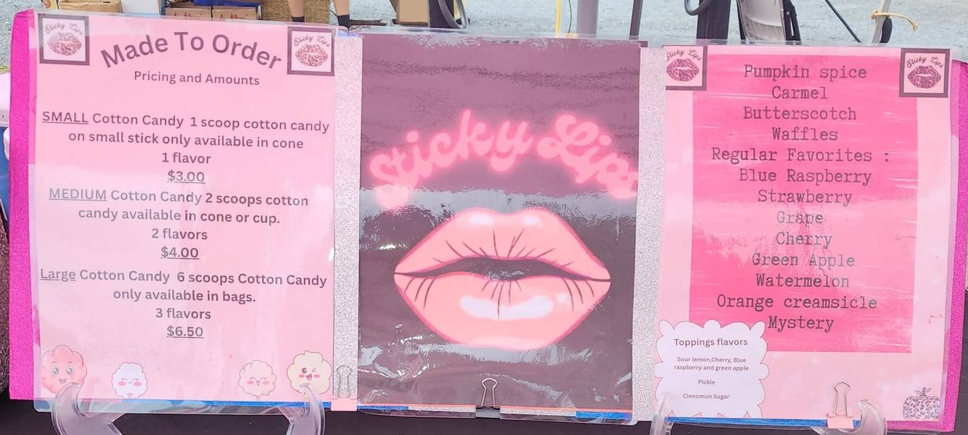 The Sticky Lips menu boards at the booth: Made To Order sizes and prices on the left, the neon Sticky Lips logo in the middle, and the flavor board on the right